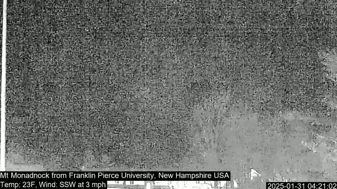 A low-resolution, grayscale image shows a distant, indistinct view of a landscape in snowy or hazy conditions, with a temperature of 23°F and a south-southwesterly wind at 3 mph.