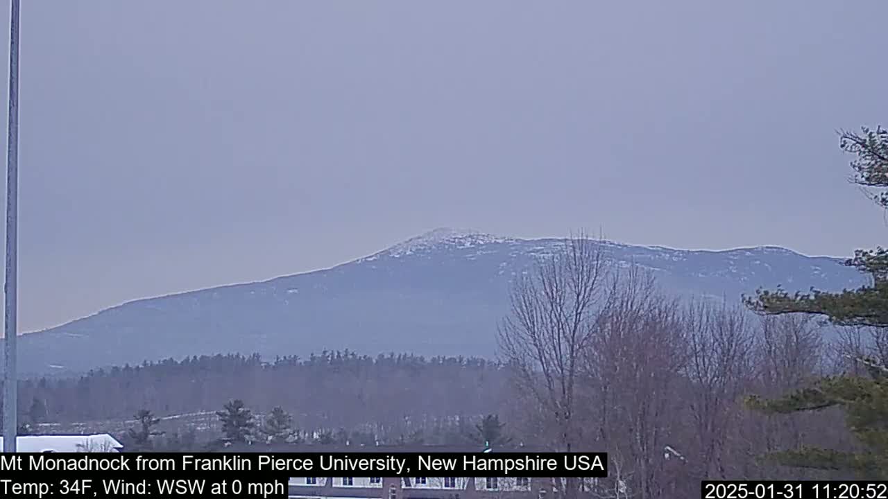 A snow-dusted mountain range is visible in the distance under a hazy, light-grey sky.