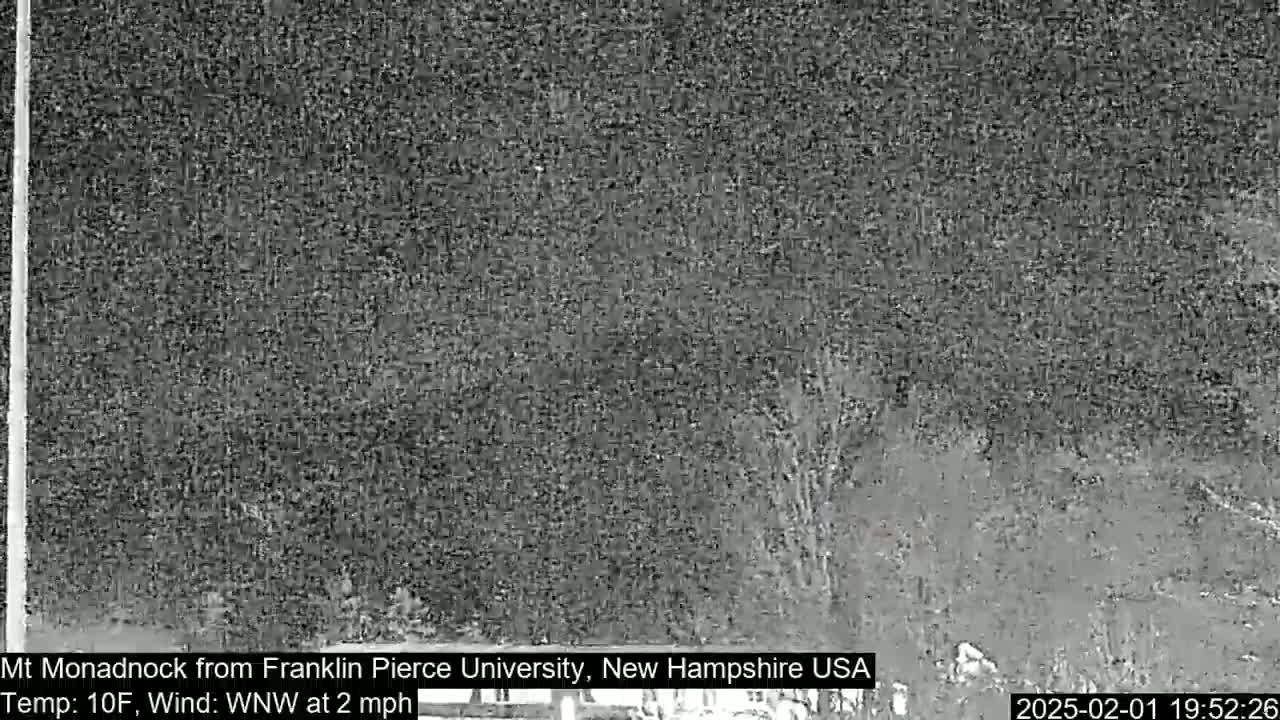 A low-light, grainy image shows a dark, indistinct landscape at night with a temperature of 10°F and a west-northwest wind at 2 mph.