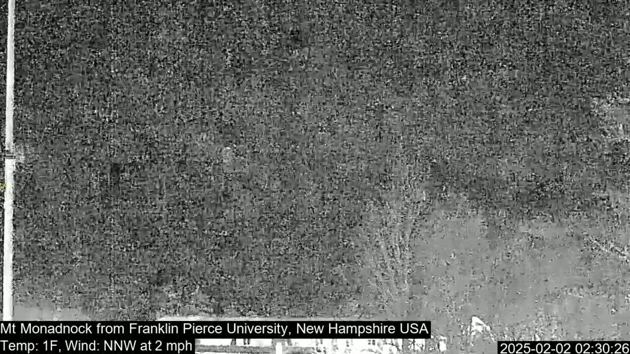 A grainy, low-light image shows a dark, indistinct view of a landscape, possibly at night, with a temperature of 1 degree Fahrenheit and a northwest wind of 2 mph.