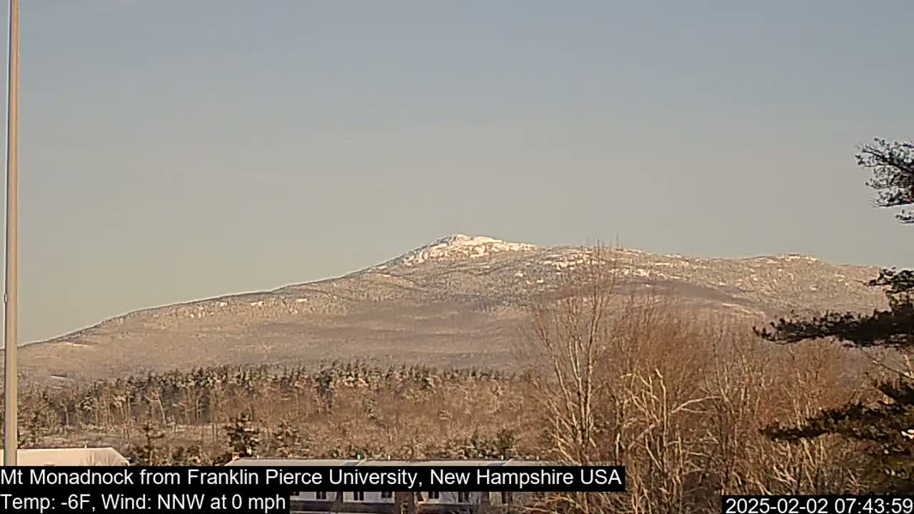 A snow-dusted mountain is visible in the distance on a clear, cold day.