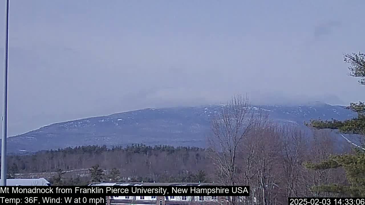 A snow-dusted mountain range is visible in the distance under a hazy sky.