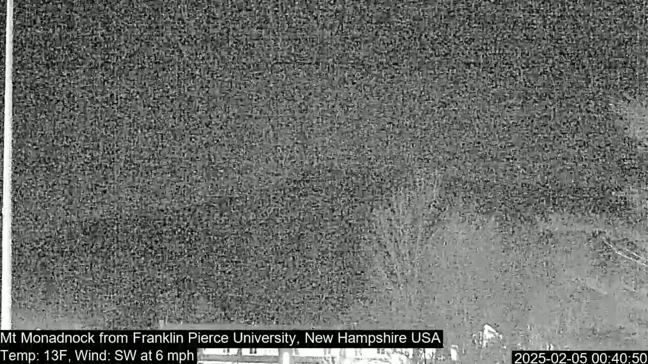 A nighttime, low-resolution image shows a dark, blurry view of a distant mountain under a cloudy sky with a southwest wind at 6 mph and a temperature of 13°F.