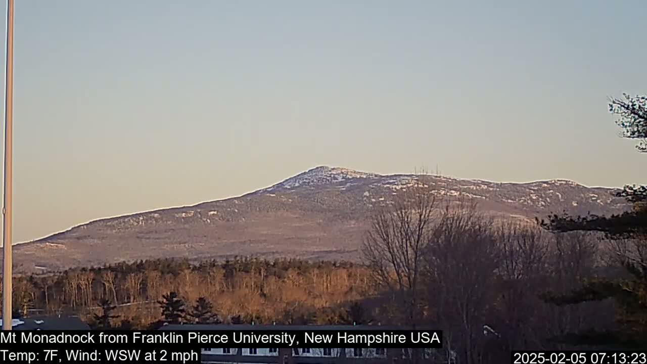 A snow-dusted mountain range is visible in the distance under a clear, light-blue sky.