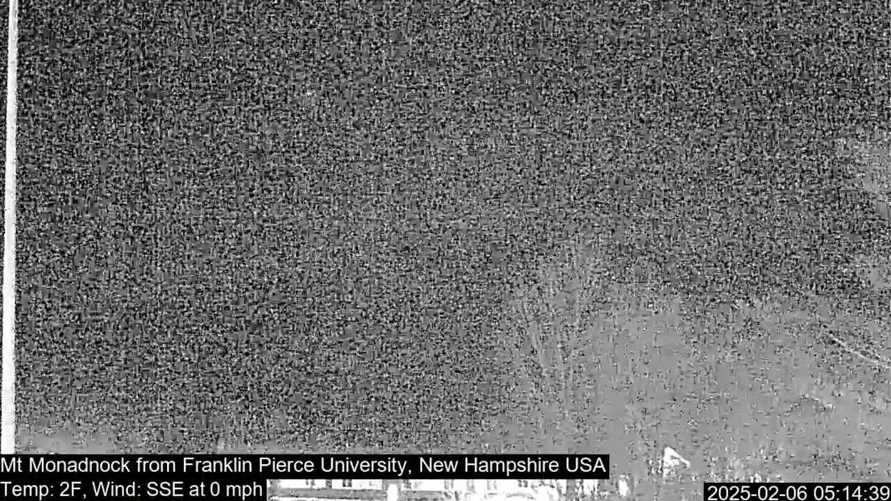 A low-quality, grainy image shows a dark, snowy or overcast outdoor scene at night with a calm wind.