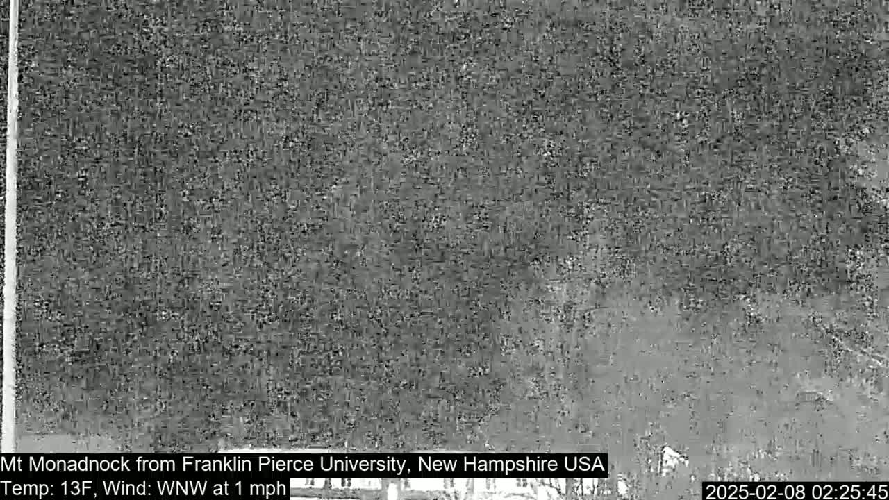 A grainy, low-light image shows a distant, indistinct view of a landscape, under a dark sky with a temperature of 13 degrees Fahrenheit and a west-northwest wind of 1 mph.
