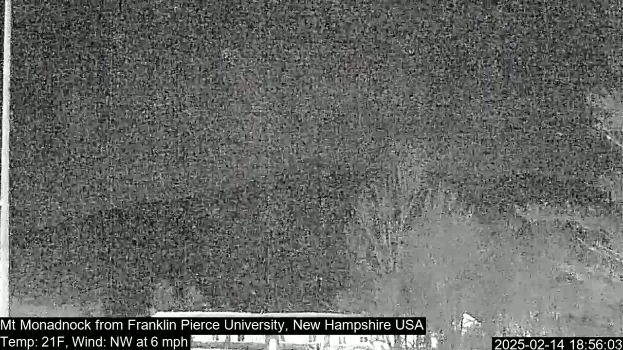 A nighttime, low-visibility view of a snow-covered landscape with a northwest wind at 6 mph and a temperature of 21 degrees Fahrenheit.