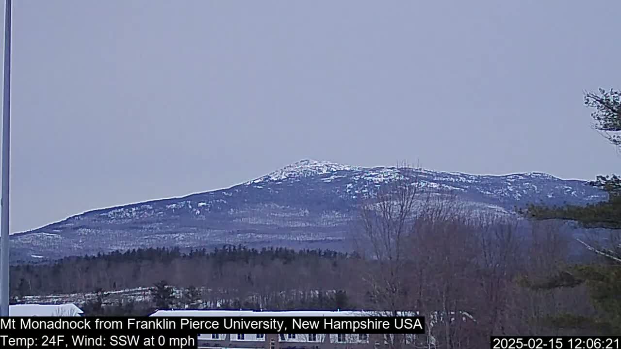 A snow-dusted mountain range is visible under a pale, overcast sky.