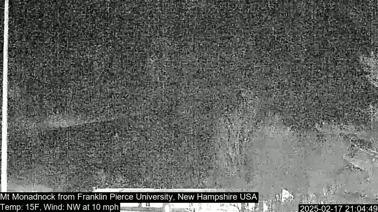 A blurry, nighttime image shows a dark, indistinct mountain range under a cloudy sky with a northwest wind at 10 mph and a temperature of 15°F.