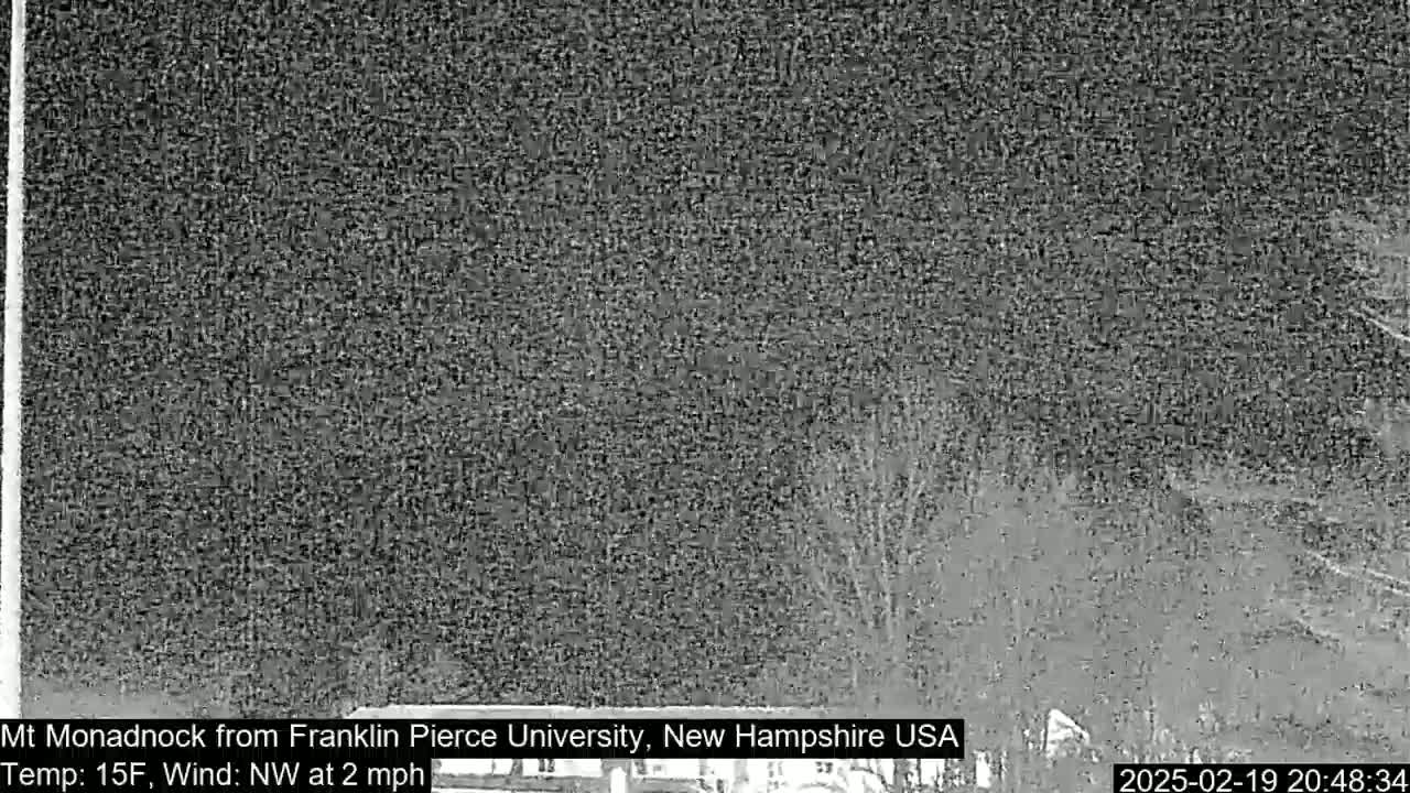 A nighttime, low-light view shows a dark, snow-covered landscape with a light northwest wind.