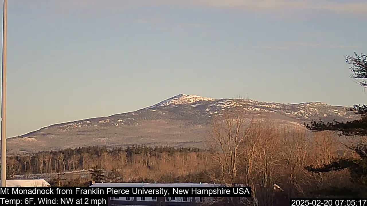 A snow-dusted mountain is visible in the distance under a clear, light-blue sky.
