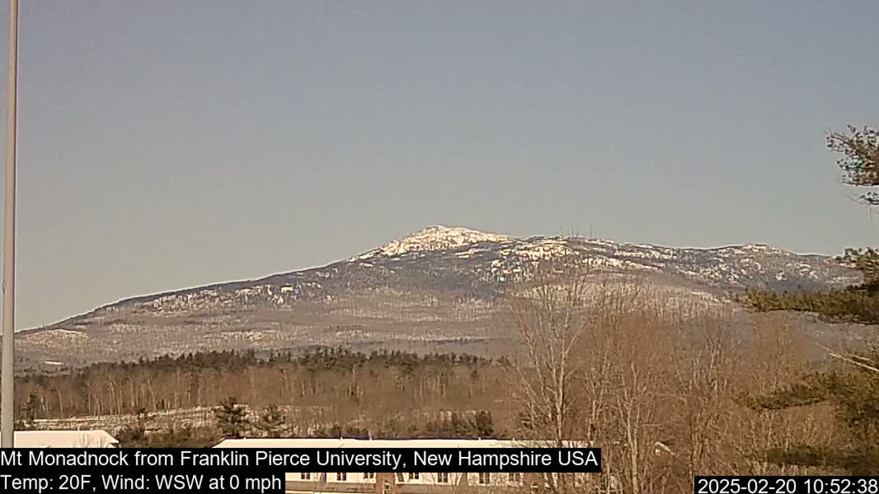 A snow-dusted mountain range is visible in the distance on a clear, cold day.