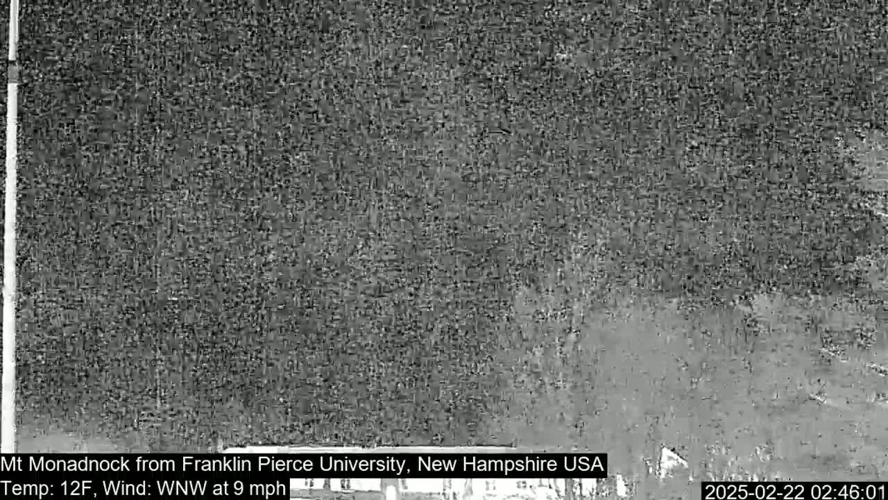 A nighttime, low-light view of a snowy or icy landscape with a wind of 9 mph from the west-northwest and a temperature of 12°F.