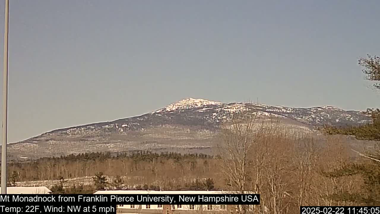 A snow-dusted mountain range is visible in the distance under a clear, light-blue sky.