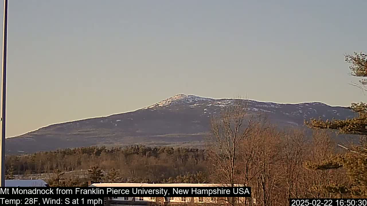A snow-dusted mountain is visible in the distance under a clear, light-blue sky.