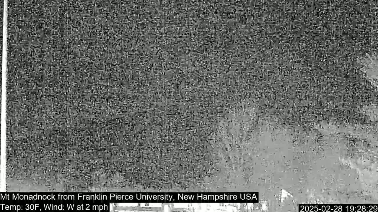 A nighttime, low-visibility view of a distant mountain under a 30°F temperature and a 2 mph westerly wind.