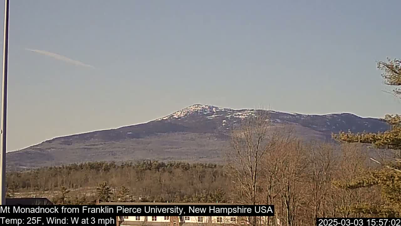 A snow-dusted mountain range is visible in the distance under a clear, light-blue sky.