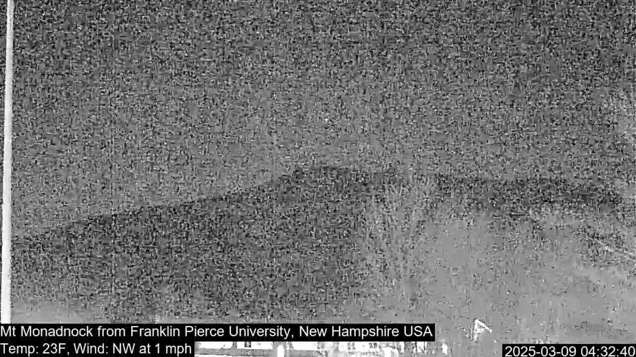 A grainy, nighttime image shows a dark, indistinct landscape under a cloudy sky with a northwest wind blowing at one mile per hour and a temperature of 23 degrees Fahrenheit.