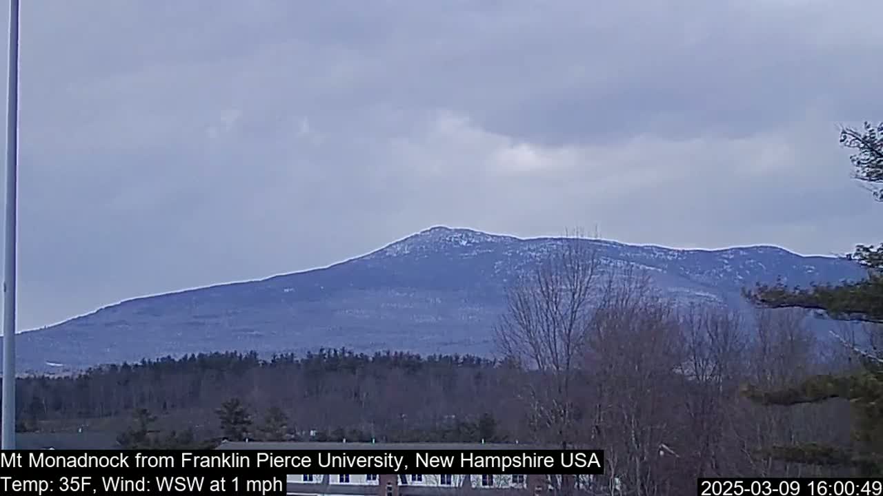 A snow-dusted mountain range is visible under an overcast sky.