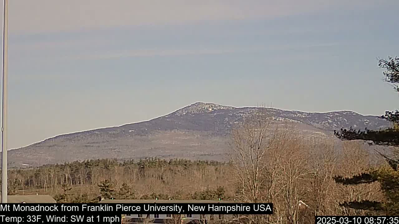 A snow-dusted mountain range is visible in the distance under a clear, light-blue sky.