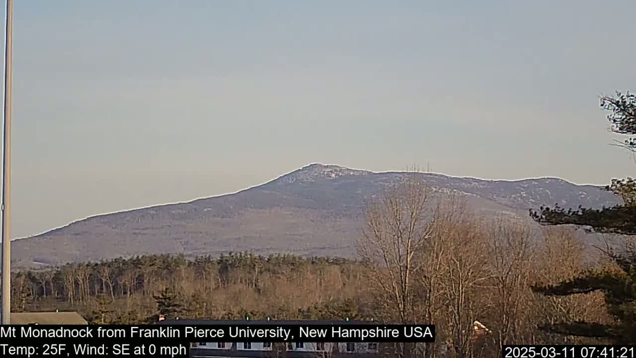 A snow-dusted mountain range is visible in the distance on a clear, cold day.