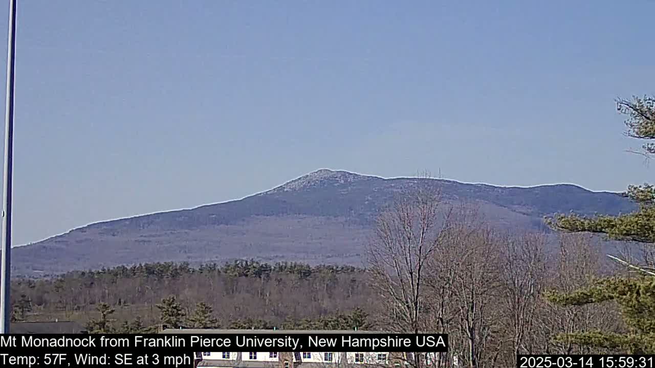 A distant mountain range is visible under a clear blue sky, with a light southeast wind blowing at 3 mph and a temperature of 57°F.