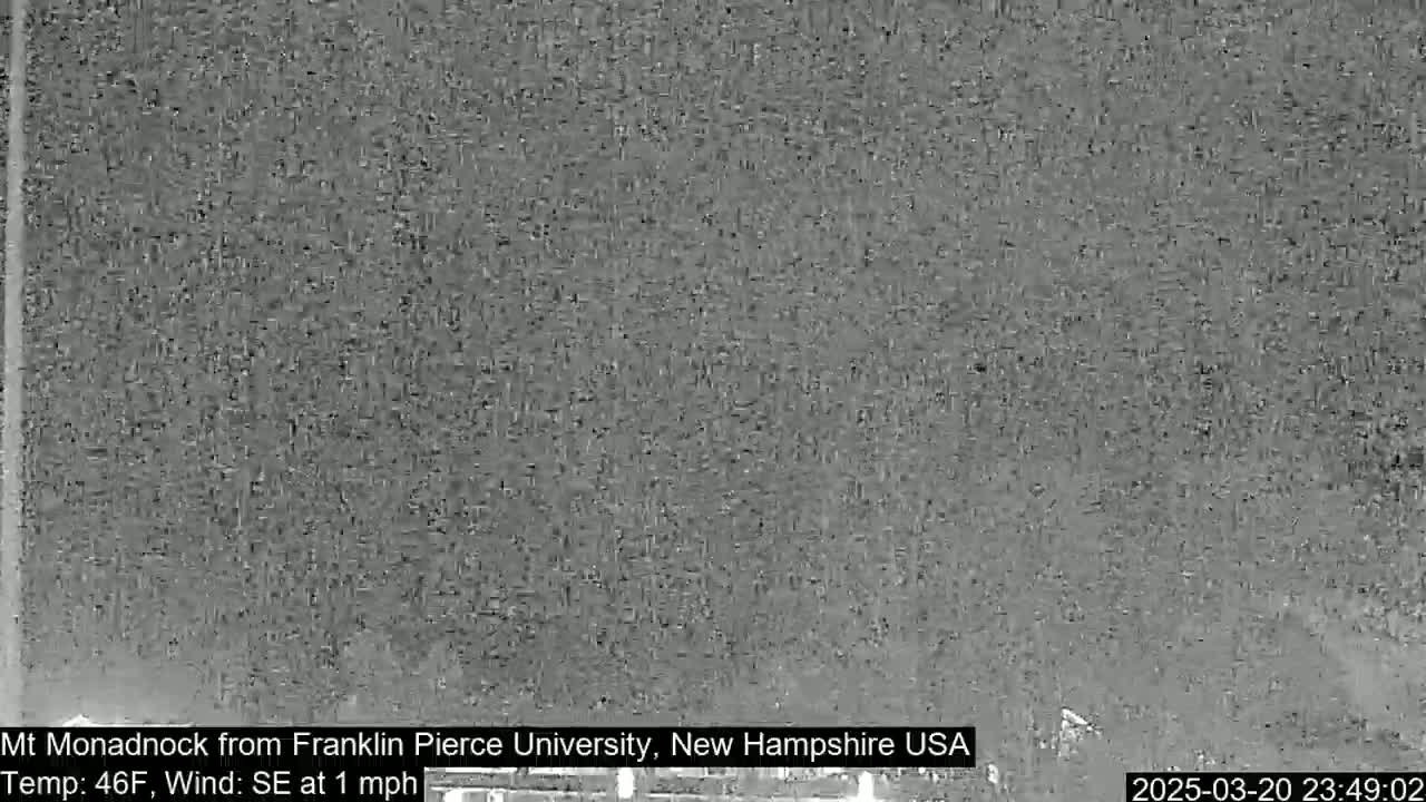 A grainy, nighttime image shows a dark, indistinct view of a landscape under a clear sky.