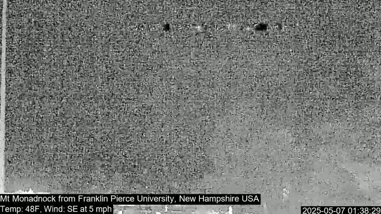 A grainy, low-resolution image shows a distant mountain range on a partly cloudy day with a southeast wind at 5 mph and a temperature of 48°F.