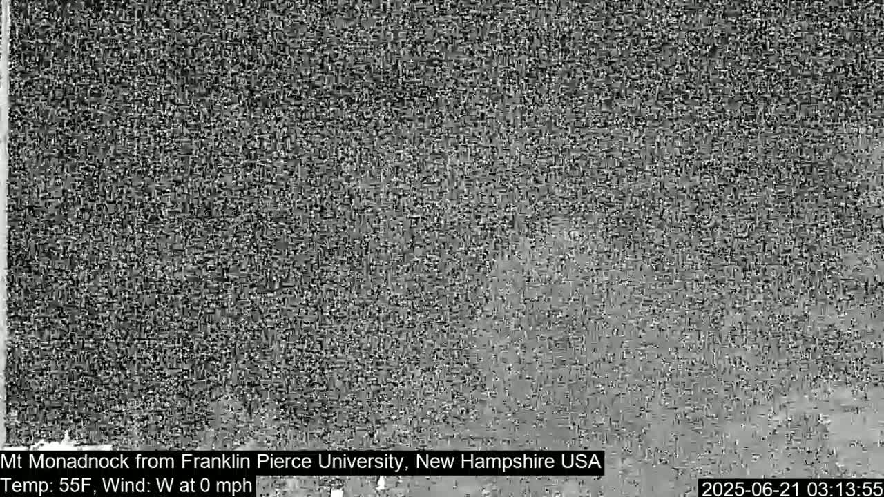 A grainy, low-resolution image shows a mostly featureless gray landscape under a seemingly clear sky.