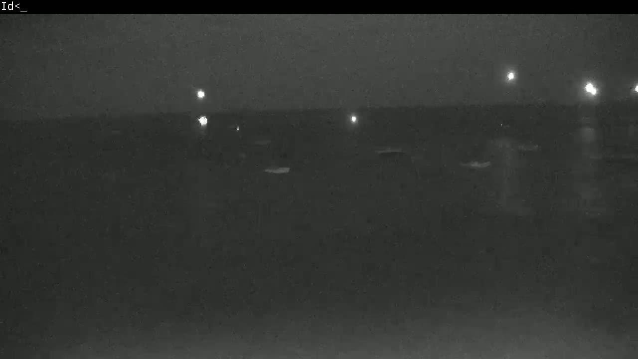 A dark, nighttime scene shows a few indistinct objects and distant lights.