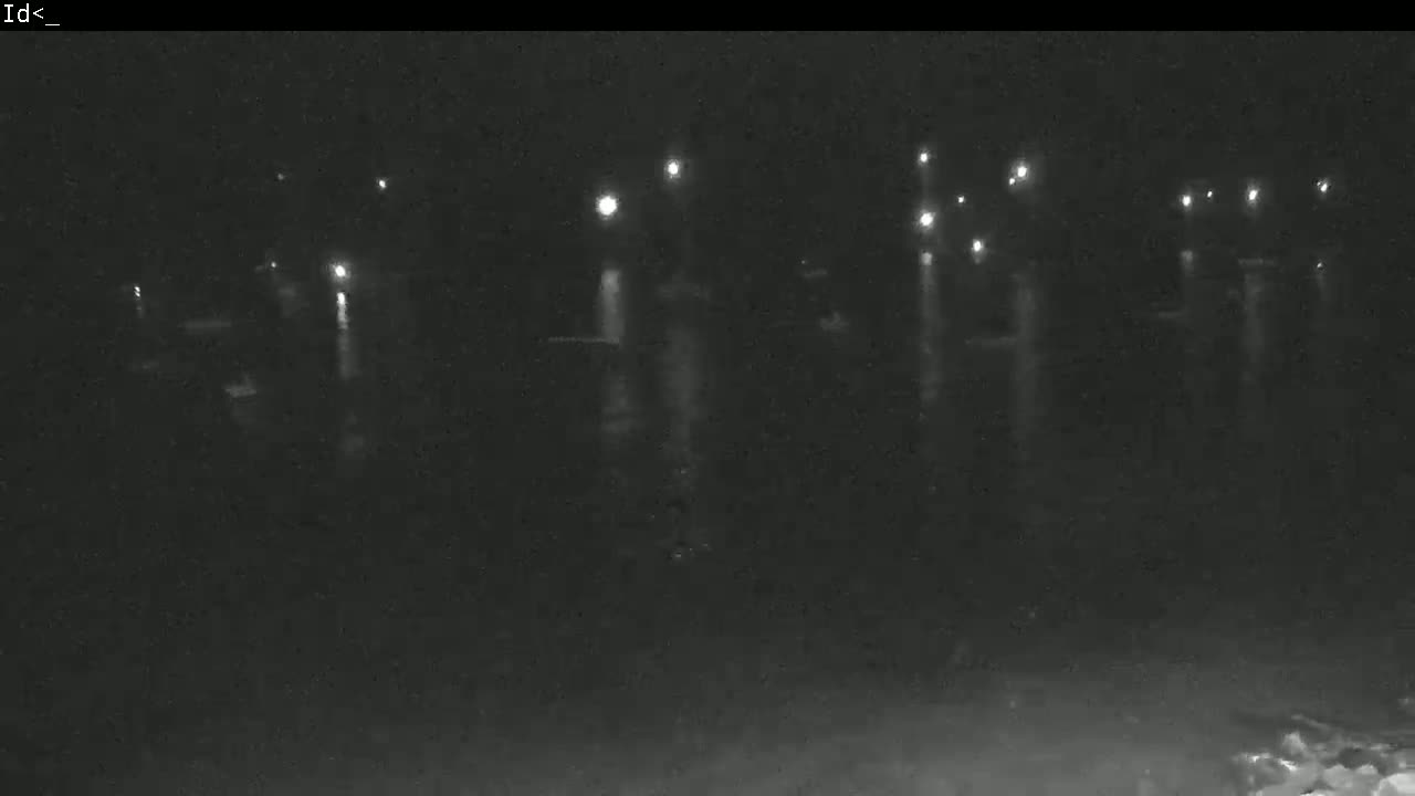 At night, numerous lights are reflected on a dark body of water.