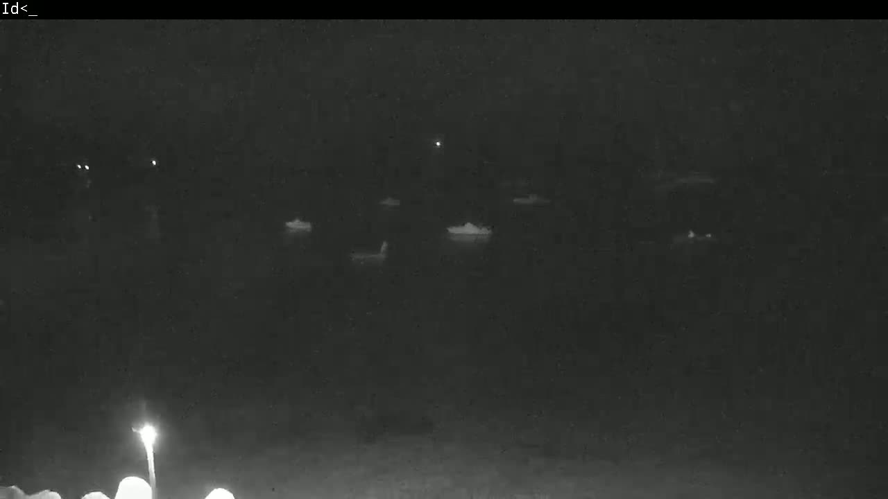 Several small, indistinct objects are visible on a dark body of water at night.