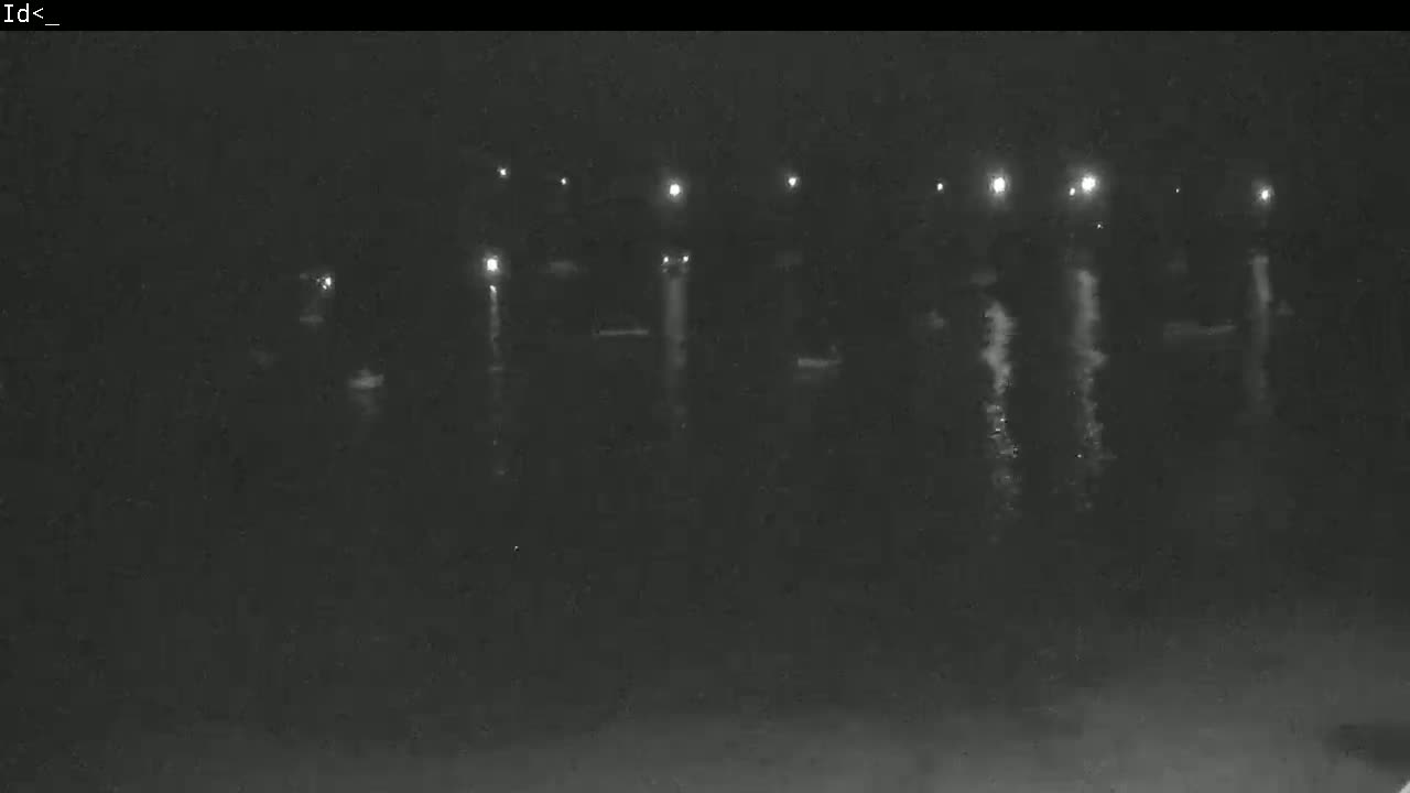 At night, several lights illuminate a dark body of water with indistinct objects on its surface.