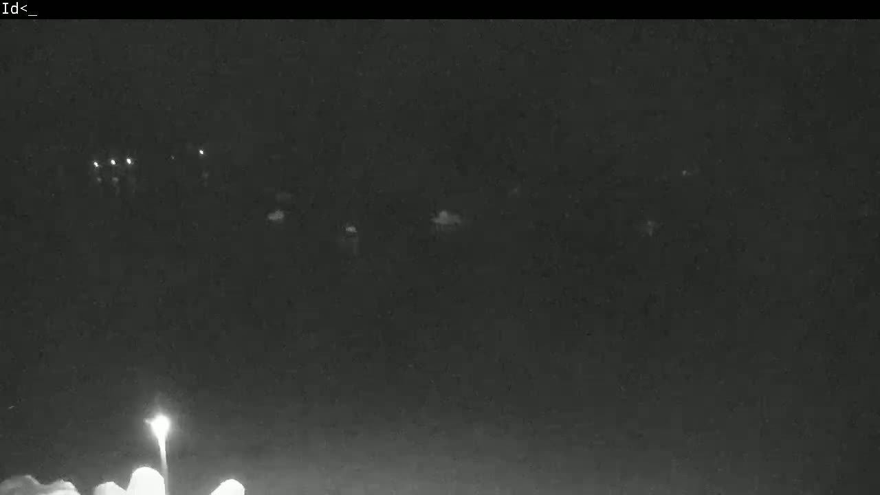 A nighttime, low-light view of faintly illuminated vehicles at a distance.