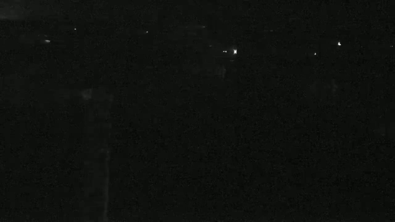A dark, nighttime scene shows a few distant lights in the background.