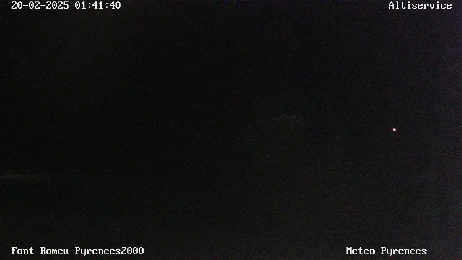 A dark, nighttime scene shows a single, faint light in the distance.