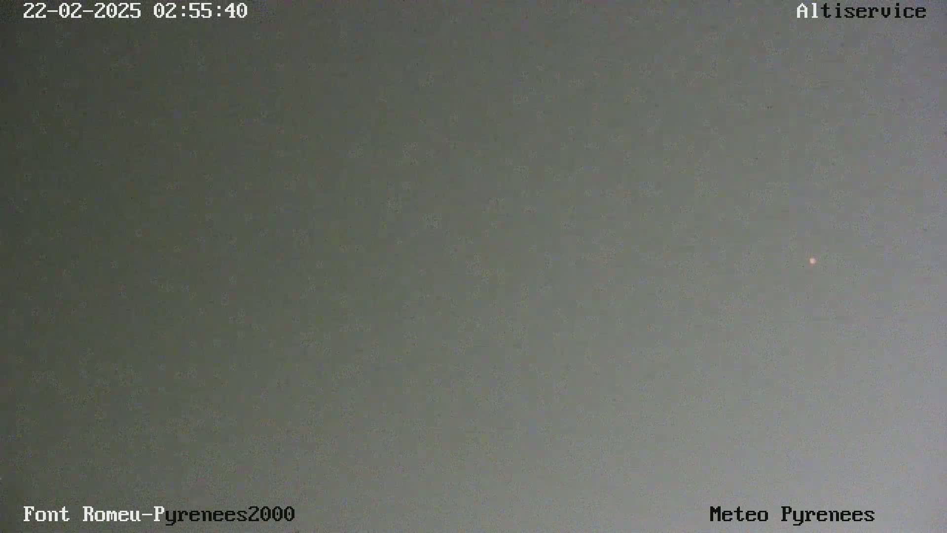 A dimly lit, overcast sky is shown with a single, small, faint light visible in the distance.