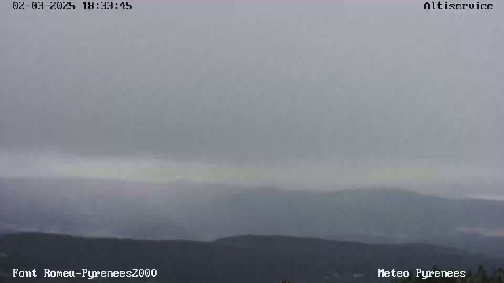 A hazy, overcast view of distant mountains under a gray sky.