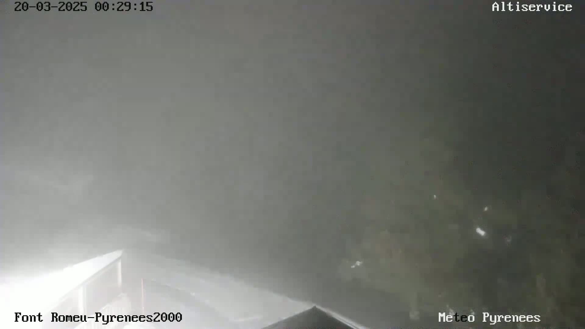 A nighttime outdoor scene is shrouded in thick fog, obscuring visibility of the surrounding landscape.