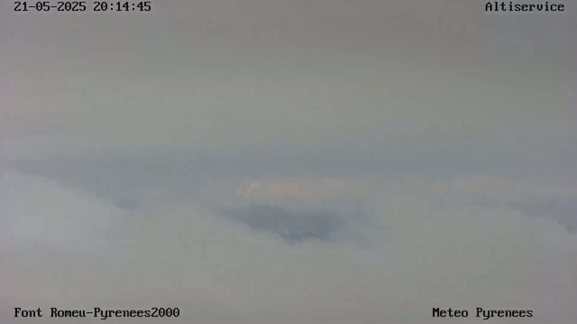 A hazy, foggy landscape is visible, with indistinct landforms shrouded in mist.