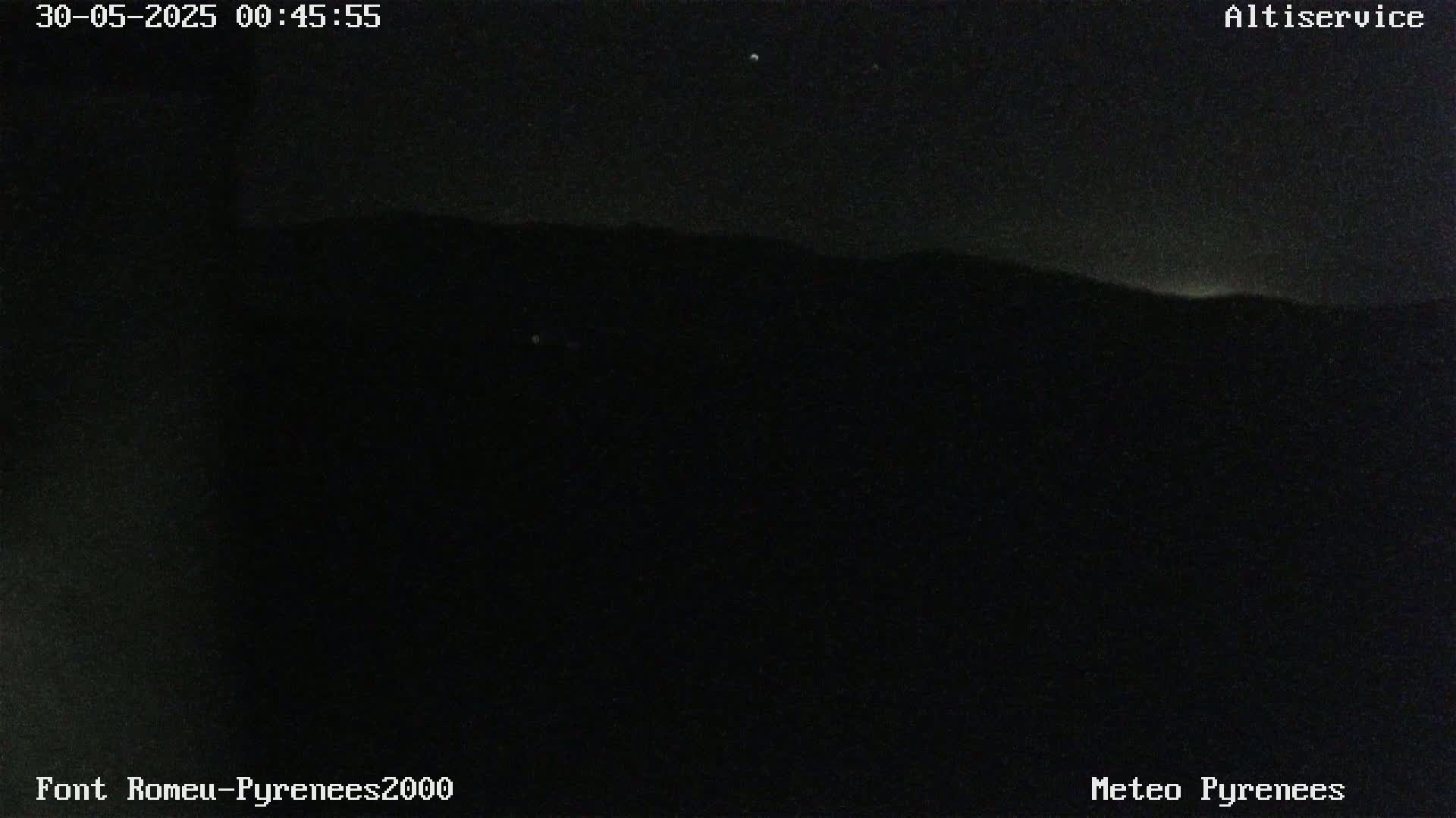 A nighttime long shot shows a dark mountain range under a clear, starlit sky.
