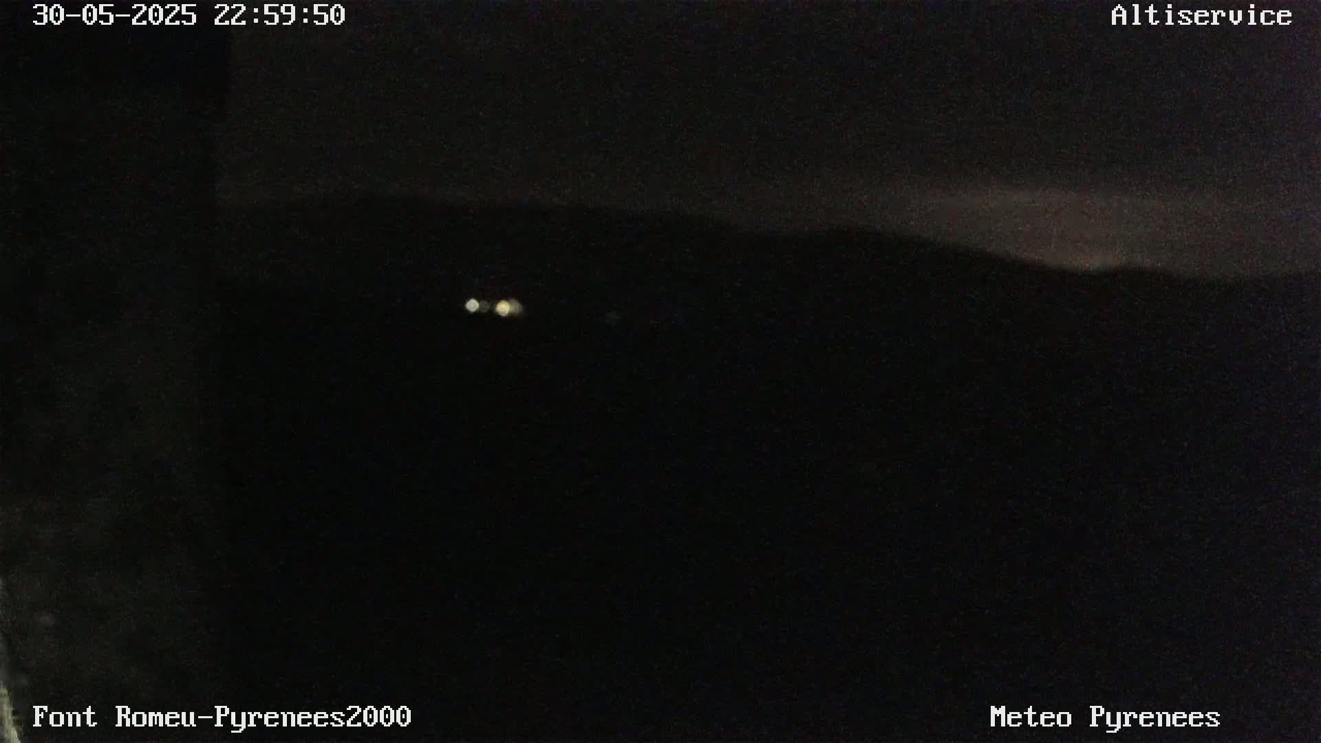 A nighttime, dark view of a distant, dimly lit landscape.