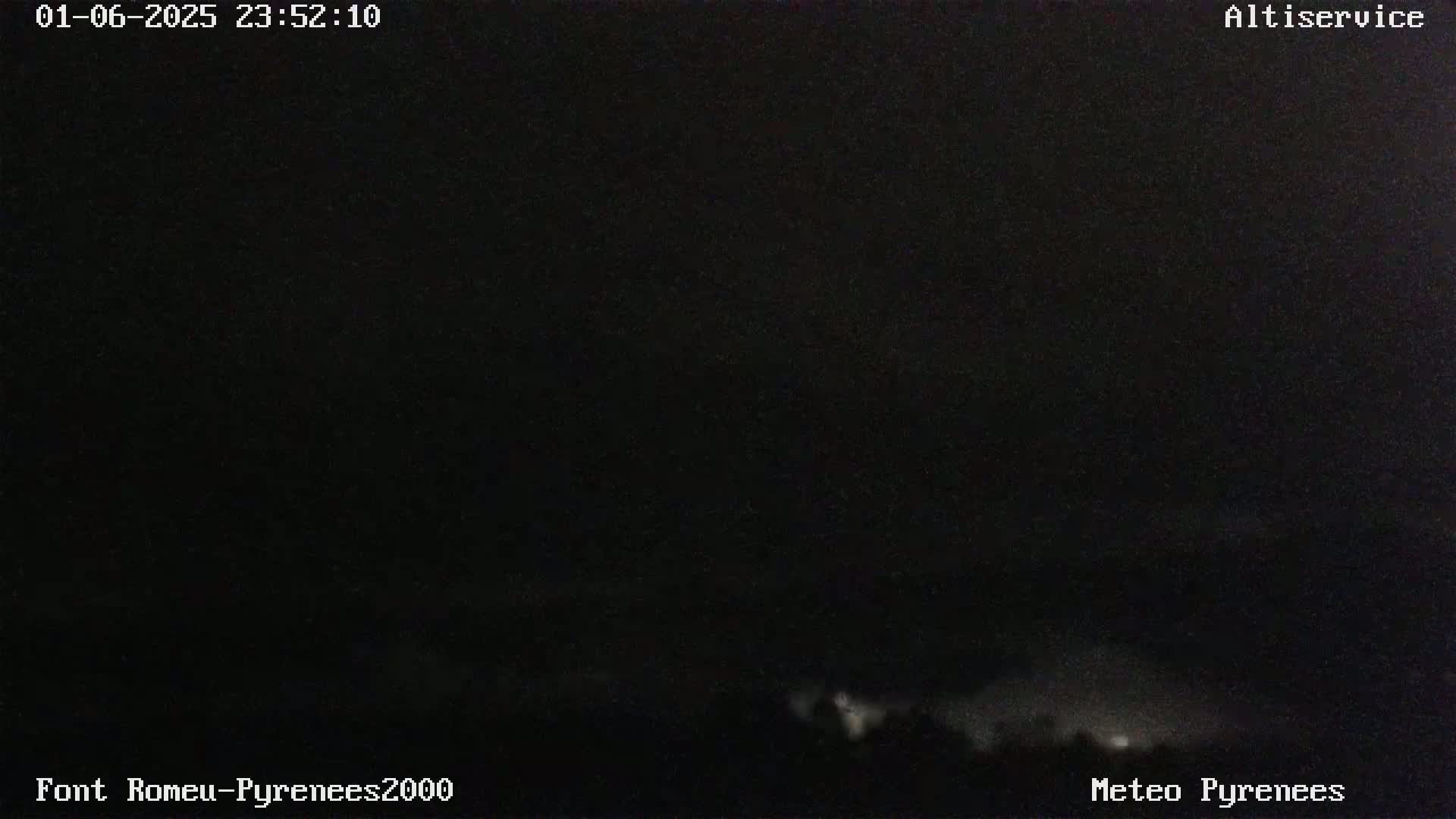 A dark, nighttime scene shows a very faint, light-grey glow on the horizon.