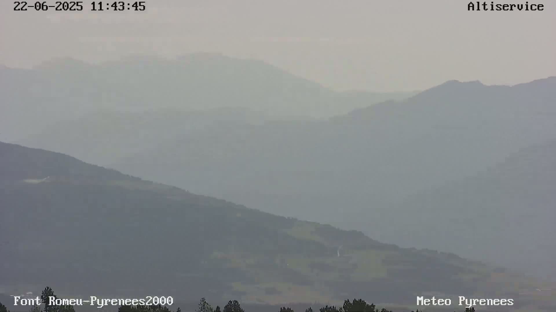 A hazy view of a mountain range under a foggy sky.
