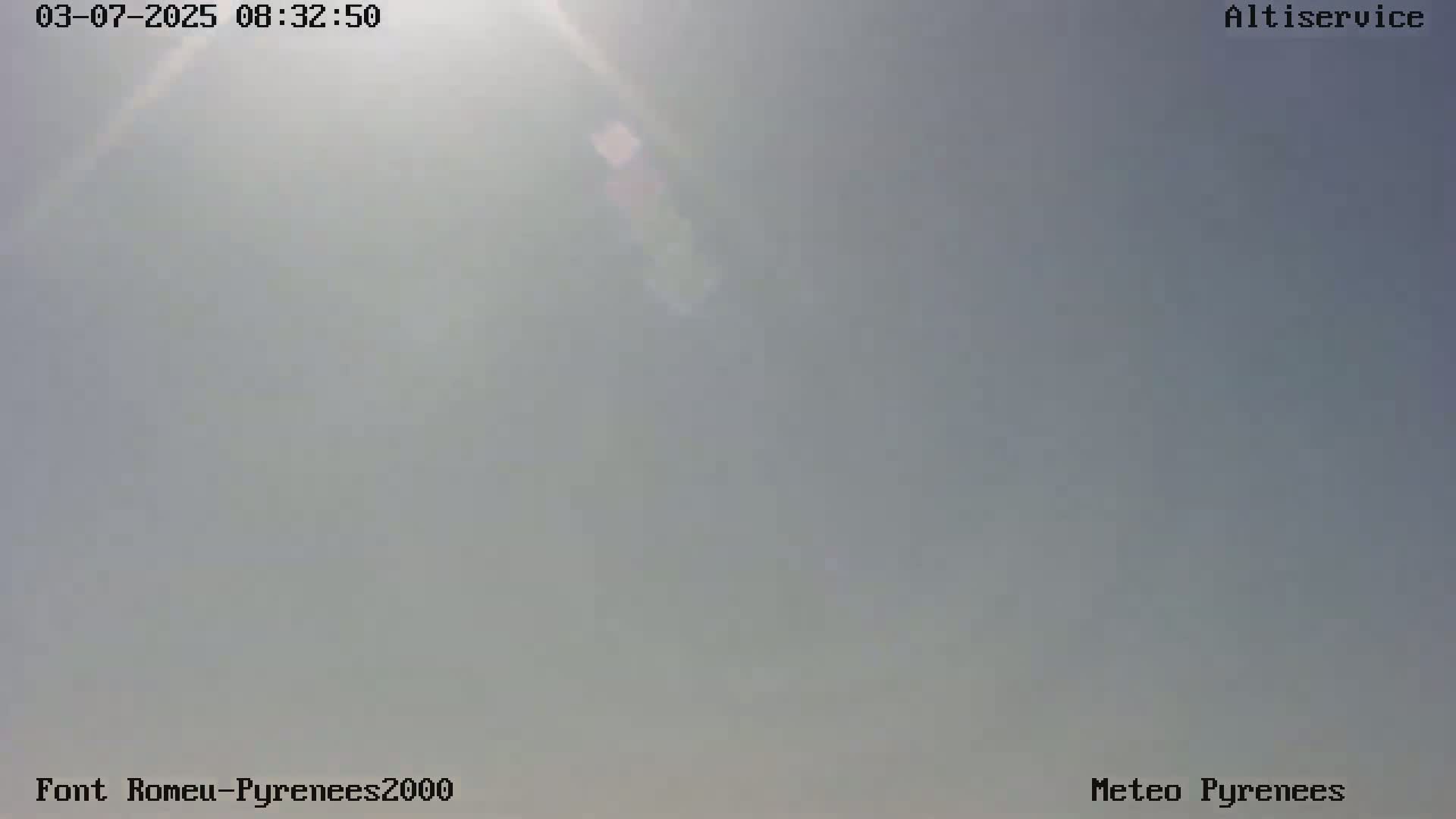 A hazy, bright outdoor scene with the sun shining through a mostly clear sky.