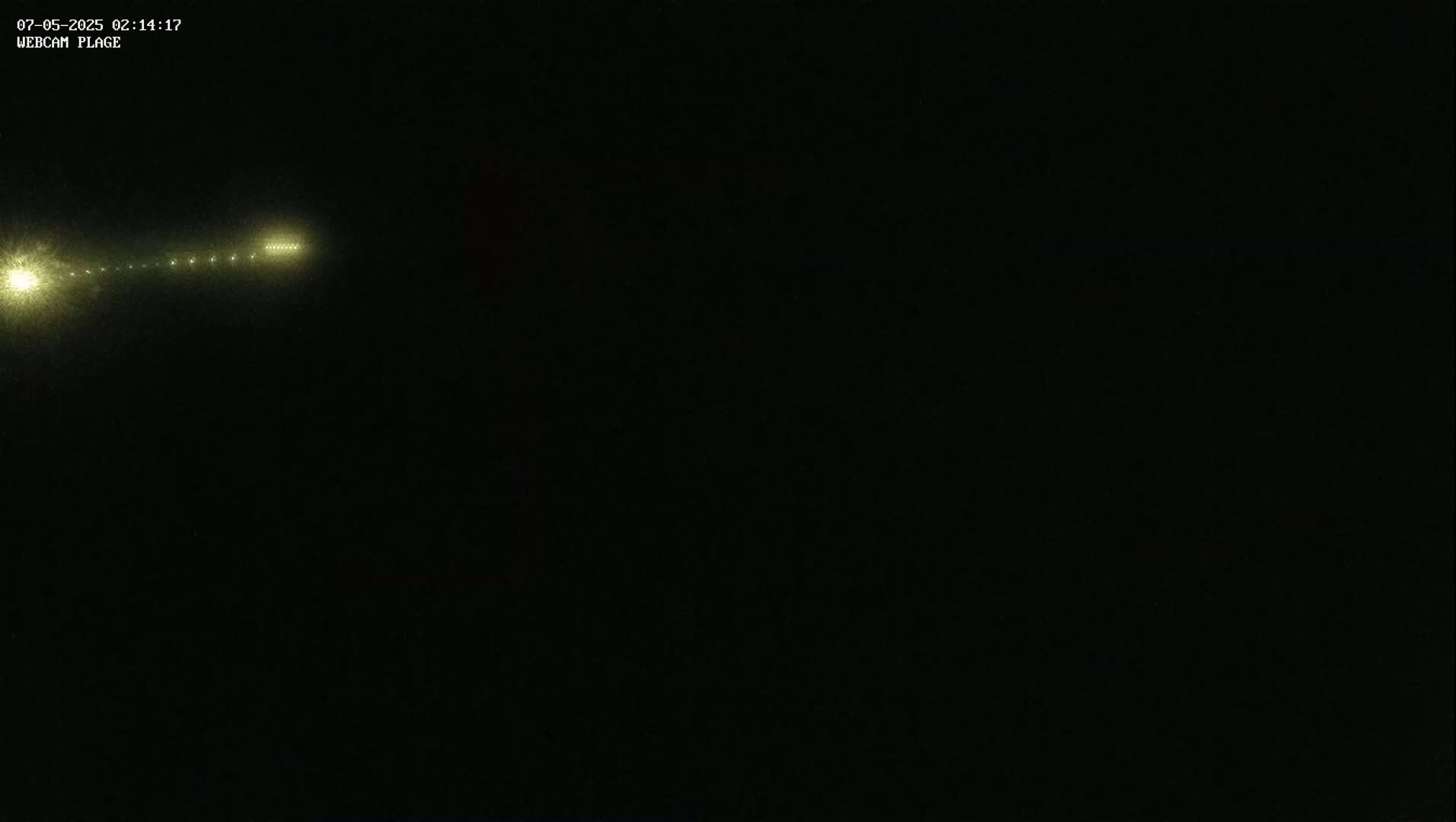 A long line of distant lights is visible in the dark night.