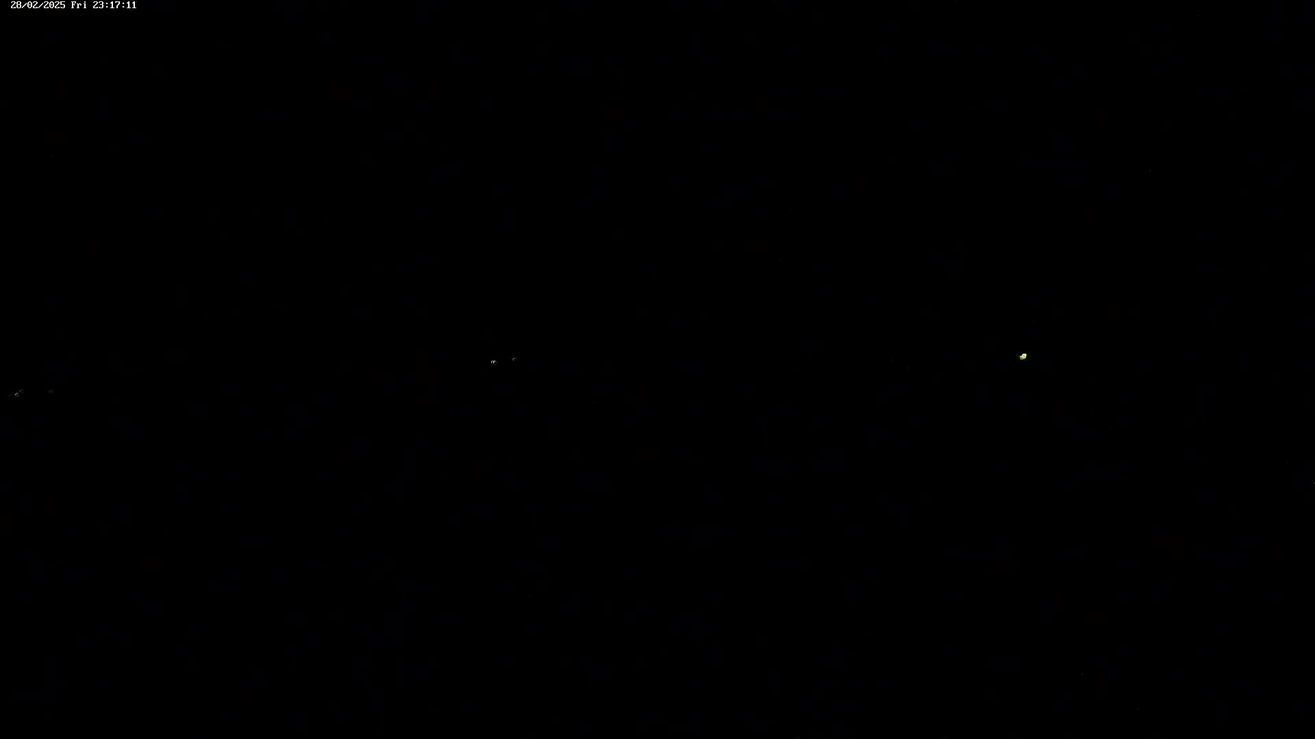 A dark, nighttime scene shows a few faint, distant lights.
