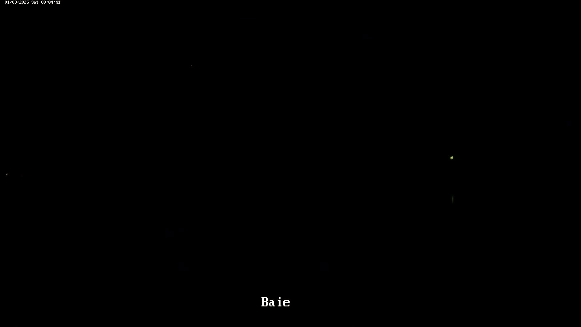 A dark, nighttime scene shows a few faint, distant lights.