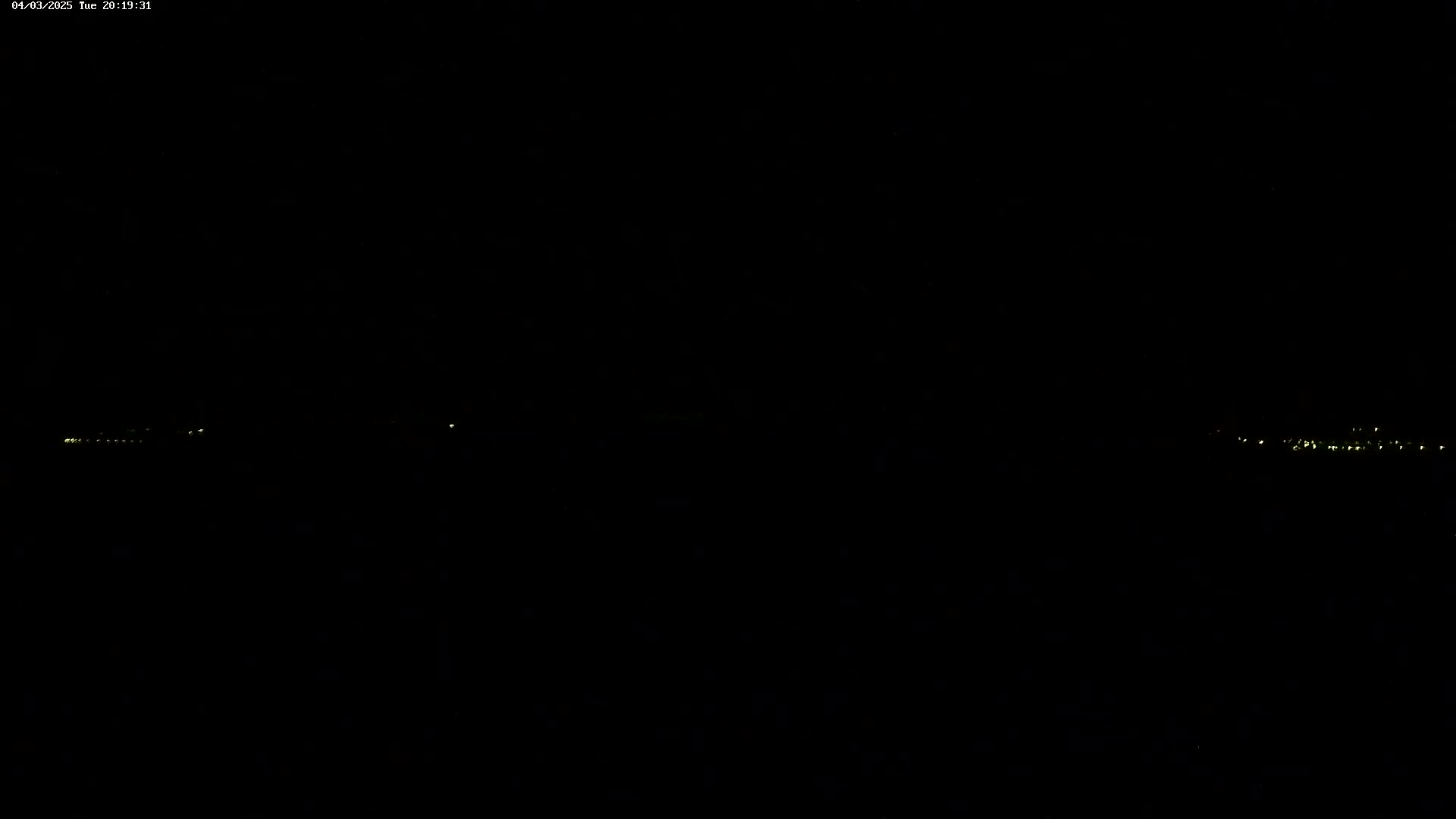 Faint, distant lights are visible on a dark, nighttime horizon.
