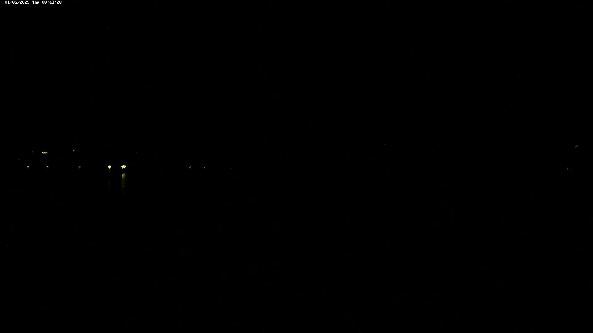 A nighttime view shows several faint, distant lights in the darkness.